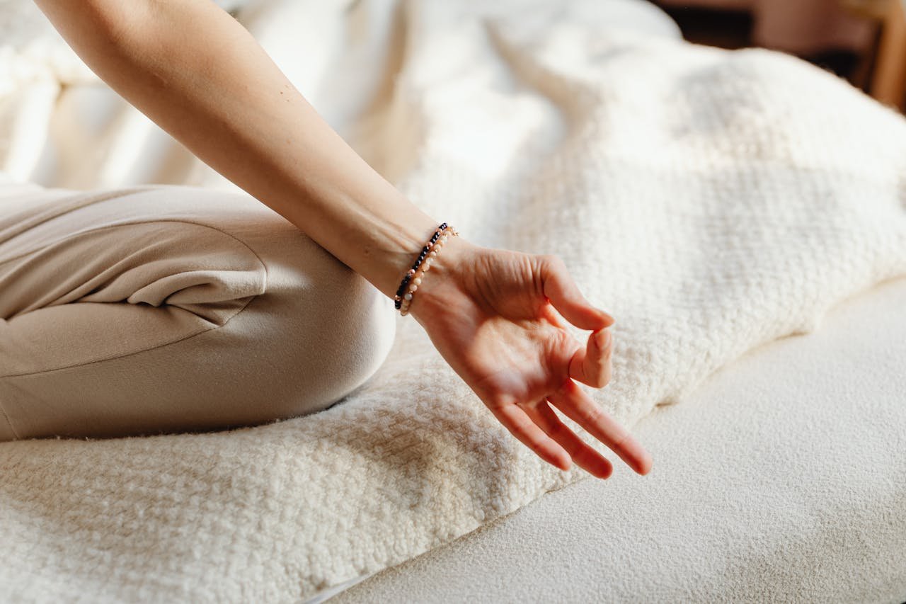 Serene image of a woman practicing meditation on a bed, embracing tranquility and relaxation.