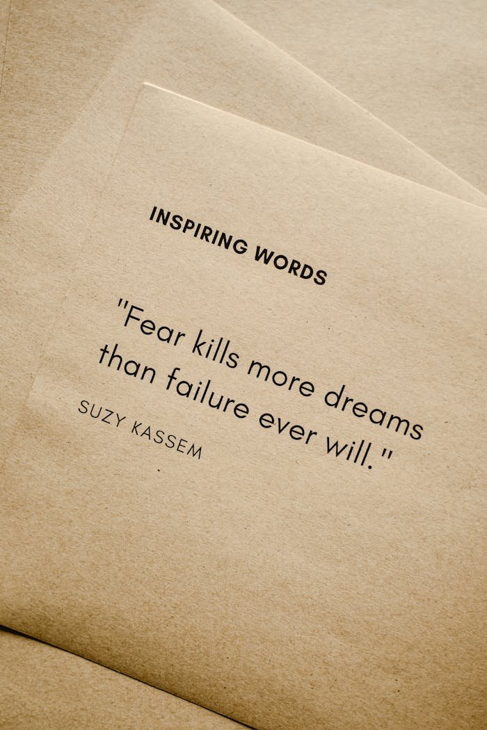 Motivational quote Fear kills more dreams than failure ever will. by Suzy Kassem on paper texture.