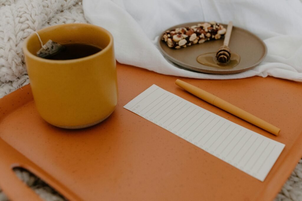 Warm setting with tea, snack bar, and notepad on a tray. Ideal for relaxation concepts.